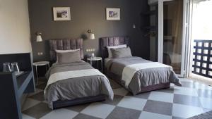 a bedroom with two beds and a checkered floor at riad casa bahia asilah in Asilah