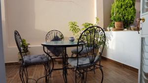 a table and chairs in a room with plants at riad casa bahia asilah in Asilah