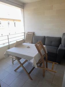 einen Tisch und Stühle im Wohnzimmer mit Sofa in der Unterkunft Superbe appartement tout équipé avec parking. in Marseille