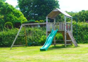 un parque infantil con un tobogán en un patio en Shicley, en Trevine