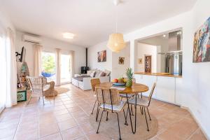 a kitchen and living room with a table and chairs at Sunset Villa Cala Tarida & Cala Comte & Cala Bassa in Port des Torrent