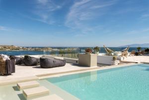 a swimming pool with a view of a resort at Villa Lilium I - Overlooking Psarou Bay, Mykonos in Psarou +47 photos