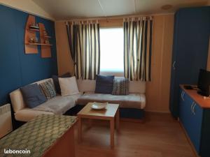 a living room with a couch and a table at Le Paradis Bleu camping les pins maritimes in Hyères