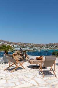 a patio with chairs and a coffee table on a roof at Villa Lilium I - Overlooking Psarou Bay, Mykonos in Psarou