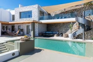 a villa with a swimming pool and a house at Villa Lilium I - Overlooking Psarou Bay, Mykonos in Psarou
