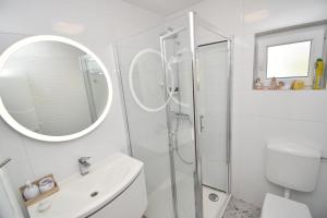 Un baño blanco con ducha y lavabo. en Helena House Bibinje, en Bibinje 19 fotos más