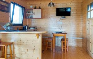 a kitchen with a bar and a tv on the wall at Lovely Home In Kladno With Kitchen in Pleśna