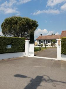 a house with a white fence and a tree at Maison d'hôtes le clos de la Presle, Compostelle in Saint-Georges-Haute-Ville