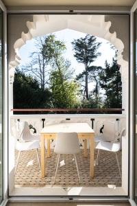 een tafel en stoelen op een patio met een raam bij Résidence Chateau d'Acotz - Appartements avec piscine à 600m des plages à Saint-Jean-de-Luz in Saint-Jean-de-Luz