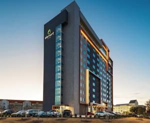 a tall building with cars parked in a parking lot at Element Dallas Las Colinas in Irving