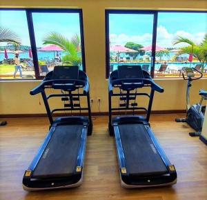 - deux vélos d'exercice dans une salle de sport avec vue sur la plage dans l'établissement Kaazi Beach Resort, à Kampala