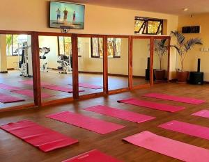 a gym with pink yoga mats in a room at Kaazi Beach Resort in Kampala
