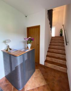 a hallway with stairs and a counter with flowers at Bellas apartmani in Novi Sad