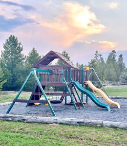 a playground with a slide and a play structure at Hibernation Station in West Yellowstone