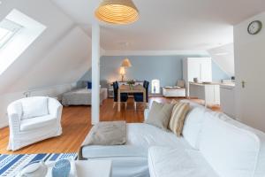 Kuestenwind في هوسوم: غرفة معيشة مع أريكة بيضاء وطاولة