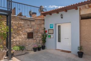 - une entrée pour un bâtiment avec une porte blanche dans l'établissement Fuentes de la Hoz, à Aguatón