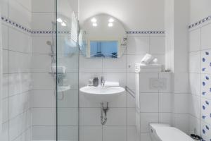 a white bathroom with a sink and a mirror at Meeresbrise in Schobüll