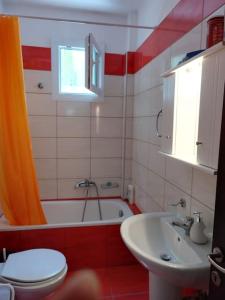 a bathroom with a toilet and a tub and a sink at Hillside house by the sea in Kokkino Nero