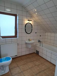 een badkamer met een wastafel, een bad en een toilet bij Ogrodowe Noclegi 