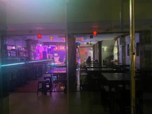 a restaurant with tables and chairs and purple lights at อีสานจอมเทียน in Jomtien Beach