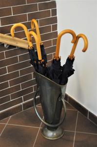 a metal bucket with two umbrellas in it at Hirscher Apartments in Braşov