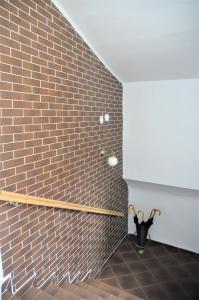 a room with a brick wall and a vase with an umbrella at Hirscher Apartments in Braşov