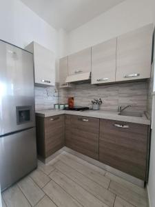 a kitchen with wooden cabinets and a stainless steel refrigerator at CASA PANDA in Luni