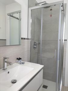 ein Bad mit einer Dusche und einem weißen Waschbecken in der Unterkunft APARTMENT VELA SUITE in Alba Adriatica