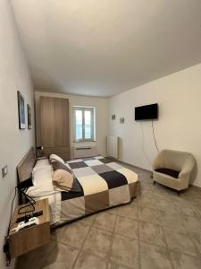- une chambre avec un grand lit et une chaise dans l'établissement Casa Valeria, à Tuscania
