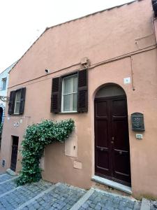 un bâtiment marron avec une porte et une fenêtre dans l'établissement Casa Valeria, à Tuscania