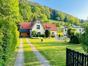 une maison au milieu d'une cour avec un chien dans l'établissement Ferienwohnung Sonnleiten, à Puchberg am Schneeberg