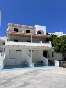 a white building with tables and chairs in front of it at Summer Time in Ios Chora