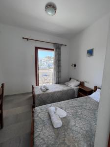 a hotel room with two beds and a window at Summer Time in Ios Chora