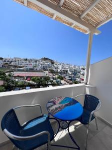 two chairs and a table on a balcony with a view at Summer Time in Ios Chora