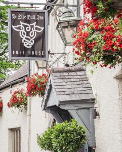 a tree house sign and flowers on the side of a building at Charming 1-Bed loft in Caerleon in Newport