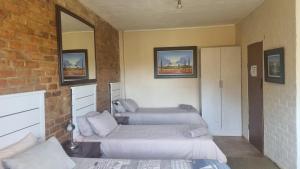 Pokój z 2 łóżkami i ceglaną ścianą w obiekcie Angel's mist guesthouse w mieście Kaapsehoop
