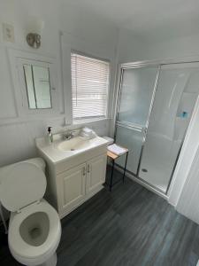 La salle de bains est pourvue de toilettes, d'un lavabo et d'une douche. dans l'établissement Nautical Beach Apartments, à Hampton Beach