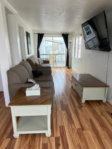 a living room with a couch and a table at Nautical Beach Apartments in Hampton