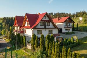 een groot huis met een rood dak bij Dworek na Wzgórzu in Rzepiska