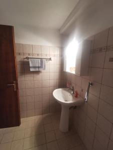 Baño blanco con lavabo y espejo en SeaL Villa, en Centro histórico de Alónnisos