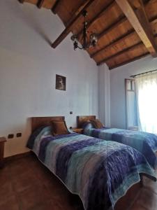 two beds in a room with wooden ceilings at SeaL Villa in Alonnisos