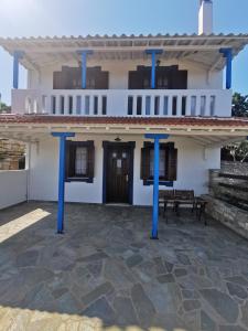 ein Haus mit blauen Säulen davor in der Unterkunft SeaL Villa in Alonnisos Altstadt