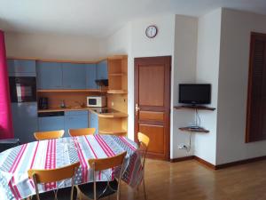 une cuisine avec une table et des chaises dans une pièce dans l'établissement Gîte Lion d'Or, à Le Bonhomme