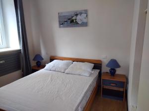 une chambre avec un lit et deux tables de nuit avec lampes dans l'établissement Gîte Lion d'Or, à Le Bonhomme