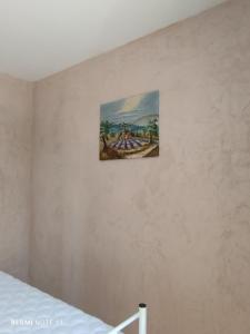 un dipinto appeso a un muro accanto a un letto di Chambre d'hôtes en Provence, au pied du Luberon "Les Coquelicots" a La Tour-dʼAigues