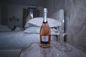 Arco Alto Rooms في باري: زجاجة من النبيذ وكأسين من النبيذ على الطاولة