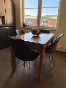 een houten tafel met stoelen en een fruitschaal erop bij Best location & large apartment in Södermalm Stockholm in Stockholm