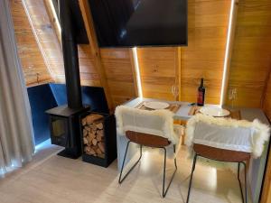 Habitación con mesa, sillas y estufa de leña. en Cabana Relax - Picada Café, en Picada Café