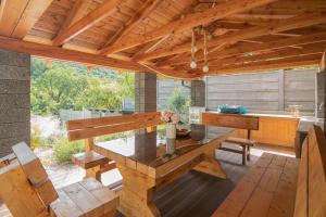 eine Terrasse mit einem Tisch und einem Holzdach in der Unterkunft Studio Apartman Alexandra in Bakarac