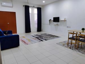 uma sala de estar com um sofá azul e uma mesa em FS Homestay Cherating em Kuantan